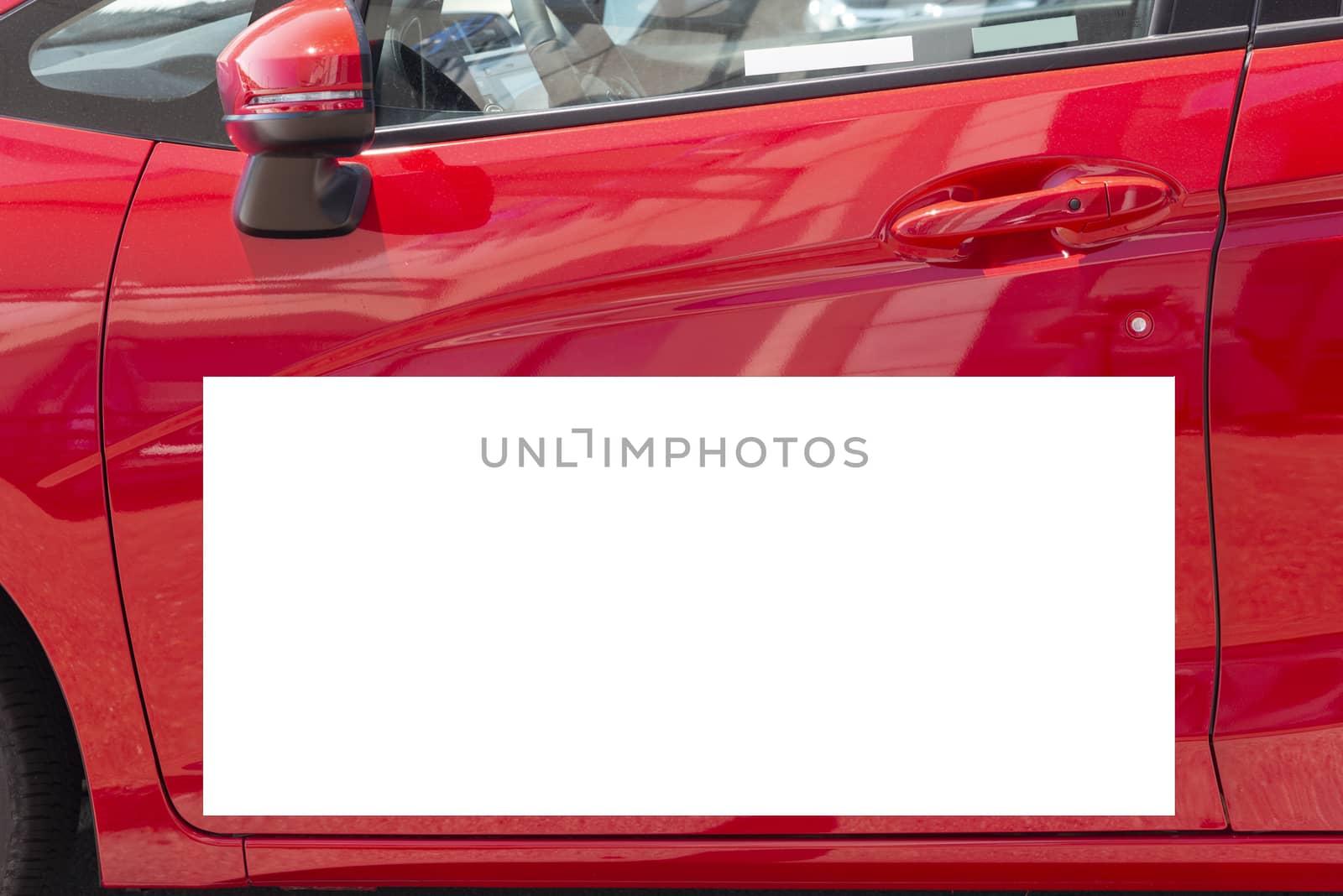 Horizontal close-up shot of a blank white sign on a red car door.