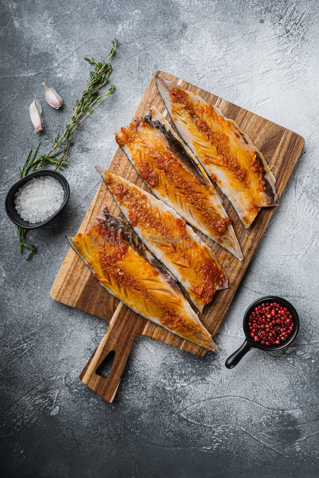 Marinated mackerel with paprika and saffron on grey background, top view.