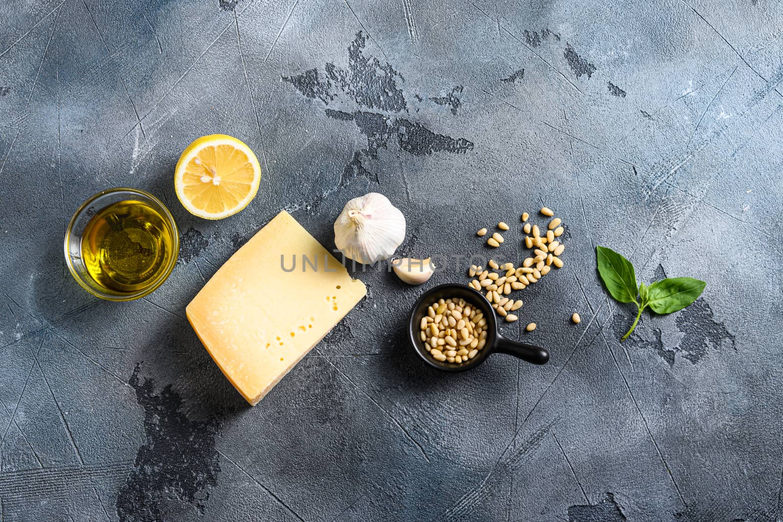 italian ingredients for pesto genovese sauce background, healthy food Basil, olive oil, parmesan, garlic, pine nuts. concept on a vintage stone grey background from above with copy space.