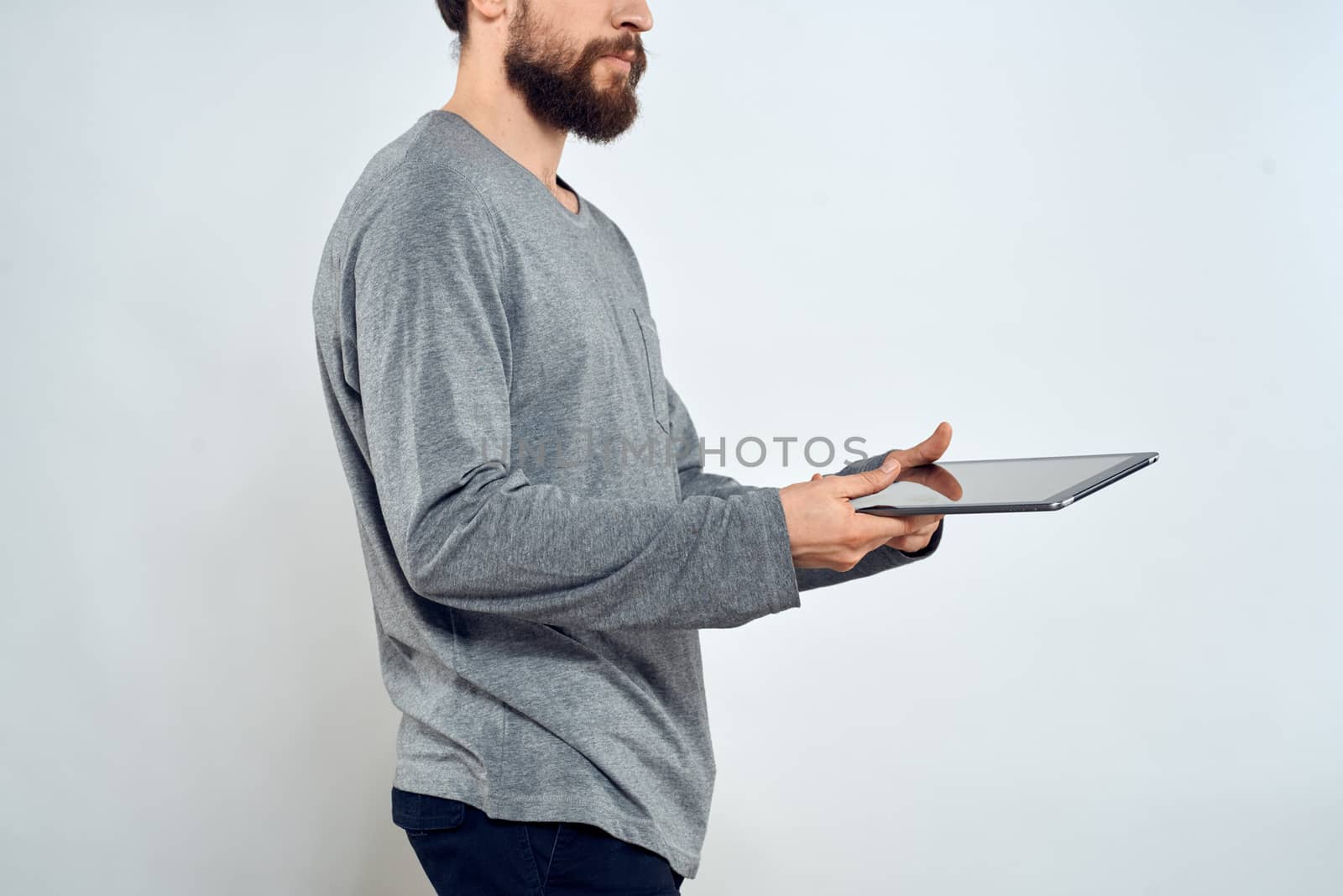 Man with tablet in hands technology lifestyle internet communication work light background cropped view. High quality photo