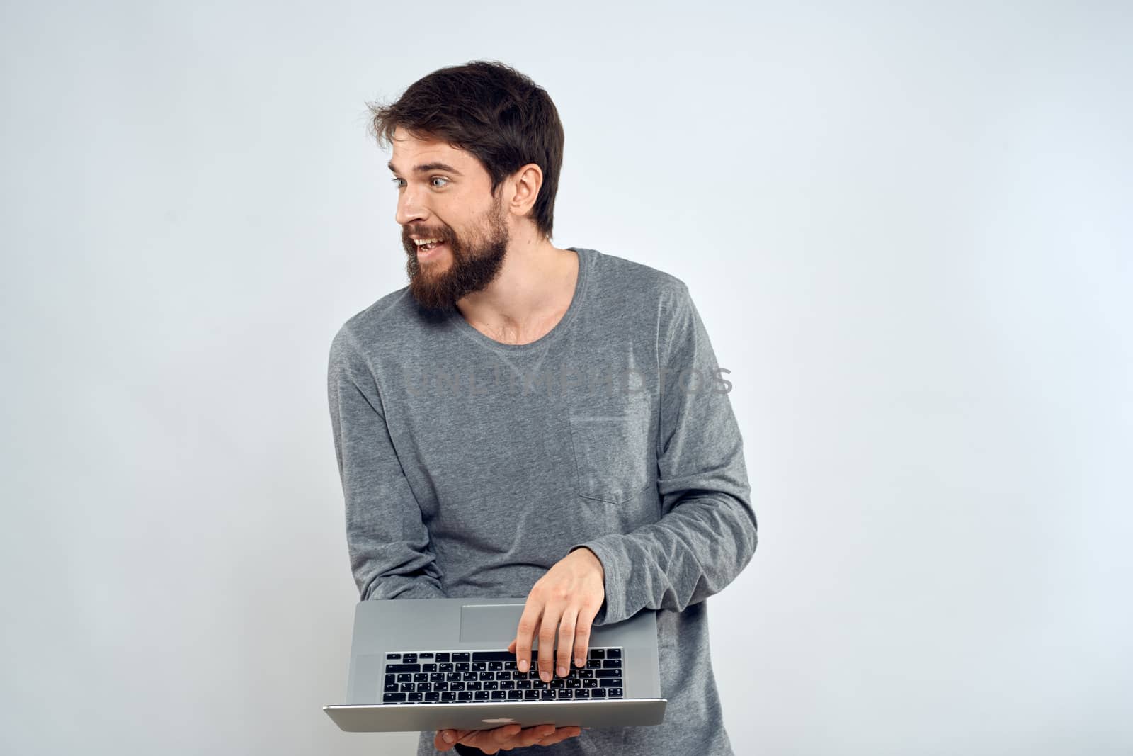 A man holding a laptop internet communication lifestyle technology light background studio by SHOTPRIME