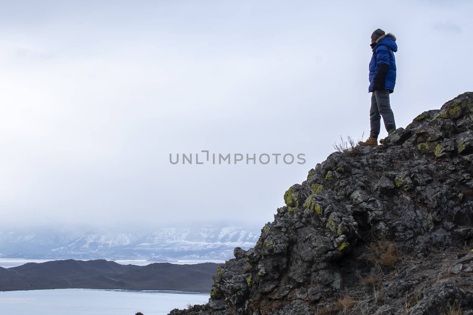 Happy man standing on cliff, man looking at landscape view