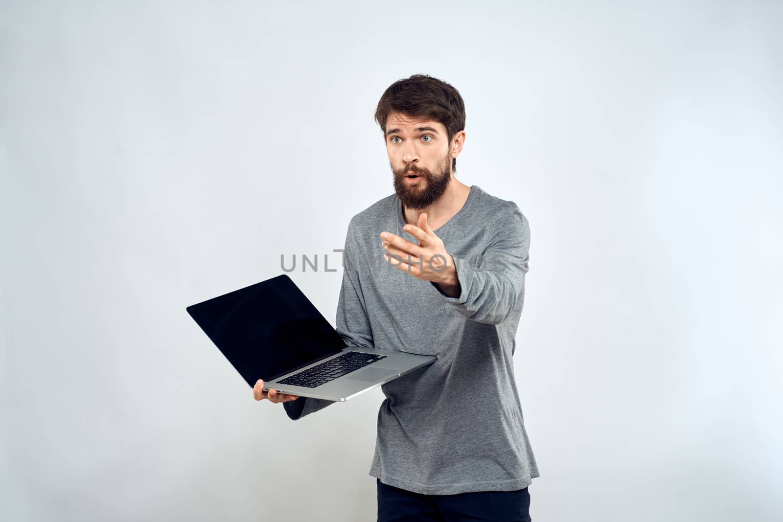 A man in a gray sweater with a laptop hands lifestyle technology communication internet work. High quality photo