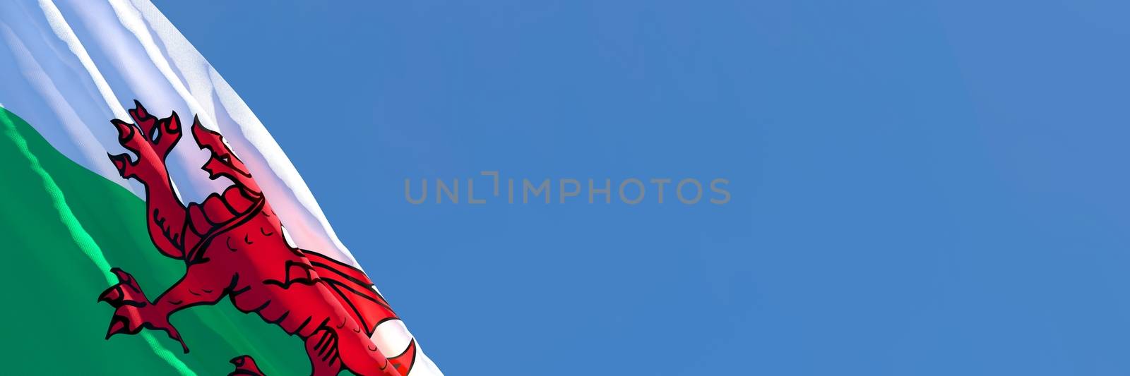 3D rendering of the national flag of Wales waving in the wind against a blue sky