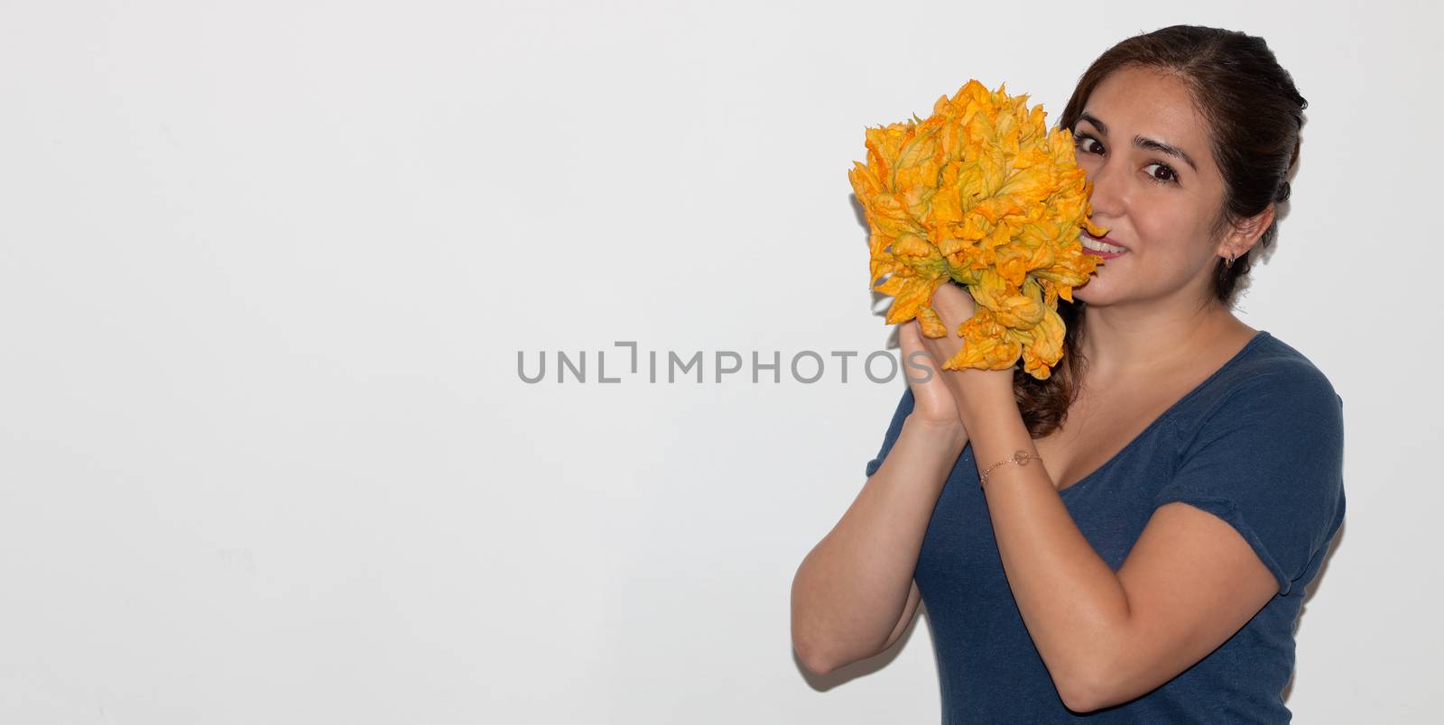 Real young man with a bunch of pumpkin flower. Isolated on a white background. Copy space
