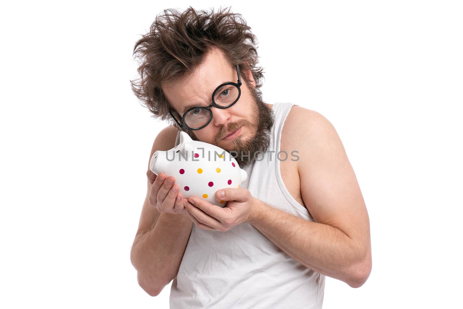 Crazy bearded Man with funny Haircut in eye Glasses holding Piggy Bank, isolated on white background. Saving Money concept. Male carefully hugging his piggybank.