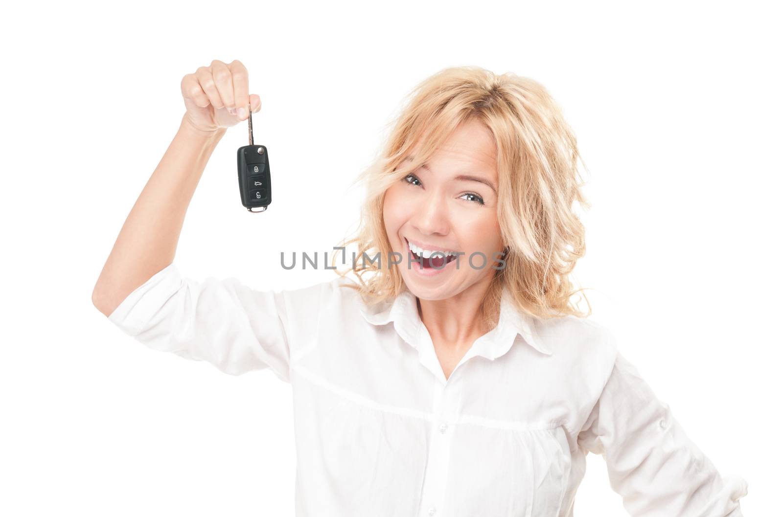 Portrait of pretty surprised young girl holding car key in her hands isolated on white background. Expression of shock, surprise and happiness. Woman got car as present or became winner.