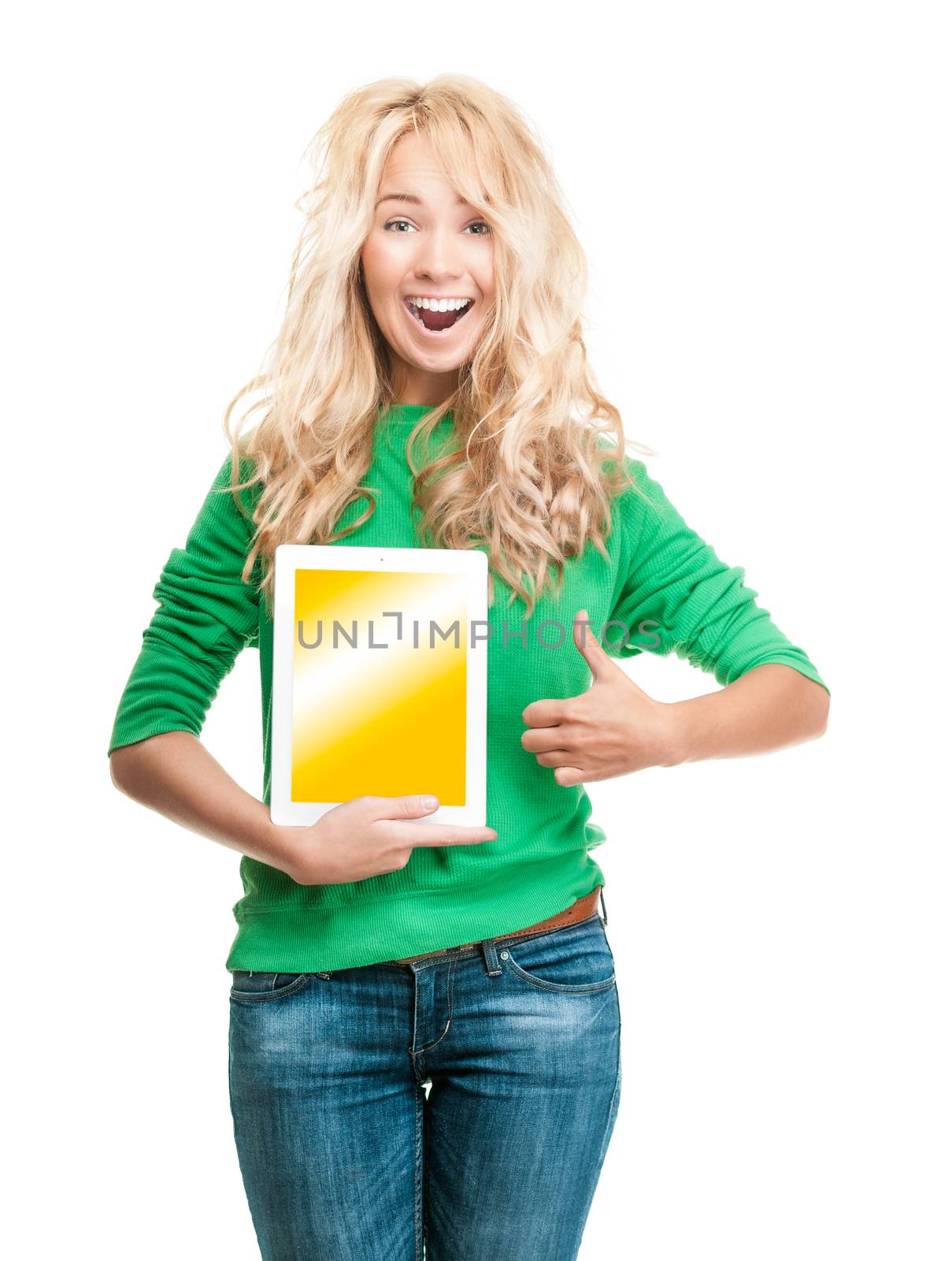 Beautiful and happy young woman standing isolated on white background. Smiling and looking into the camera. Casual style, tablet computer in her hand, thumbs up gesture with the other hand.