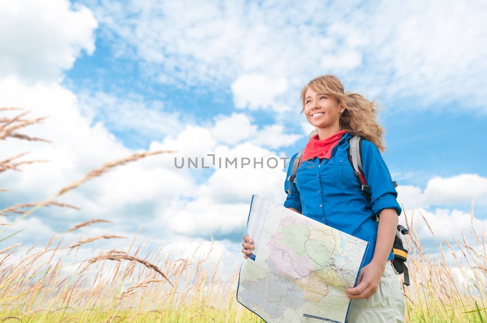 Young happy tourist woman with map in summer field. by Yolshin