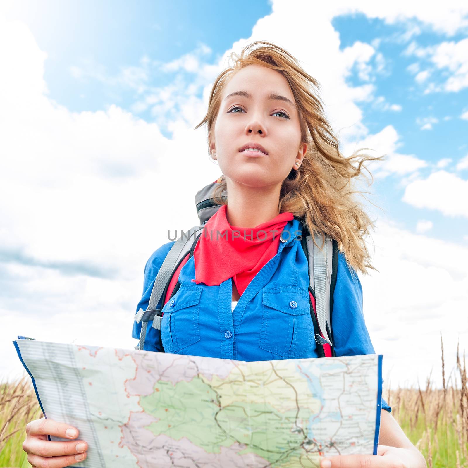 Young happy tourist woman with map in summer field. by Yolshin