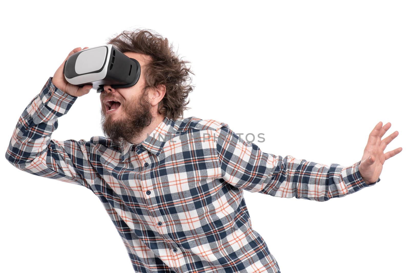 Crazy bearded Man in plaid shirt with funny Haircut wearing virtual reality helmet, isolated on white background. Portrait of funny man using VR goggles.