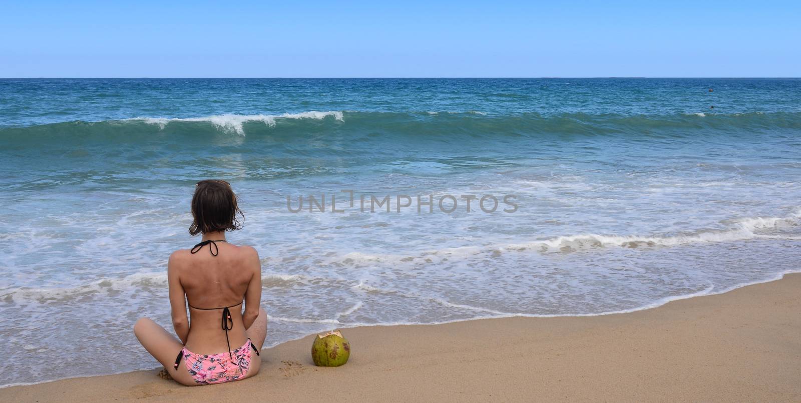 Sexy bikini body woman sitting on a beautiful beach and coconut on travel vacation. by ideation90