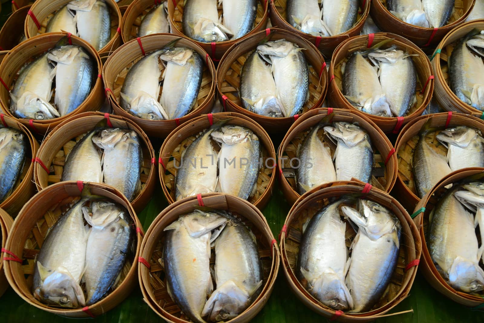 Steamed fish in the bamboo basket on banana leaf  by ideation90