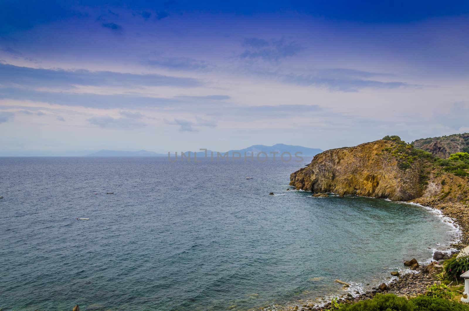 rocky beach on Panarea island and Tyrrhenian sea with other Aeolian islands in background