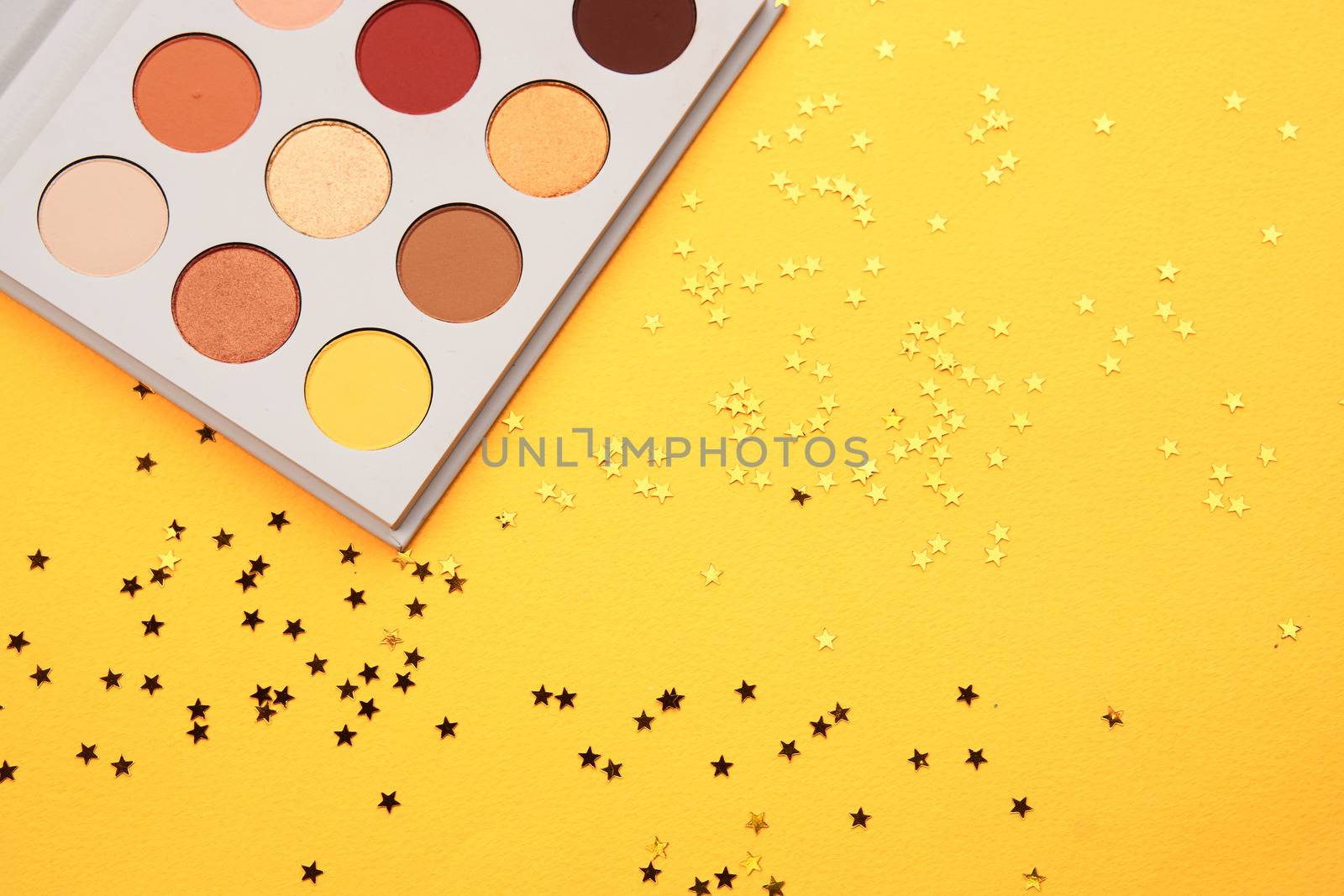 eyeshadow on a yellow background and glitter decorations. High quality photo