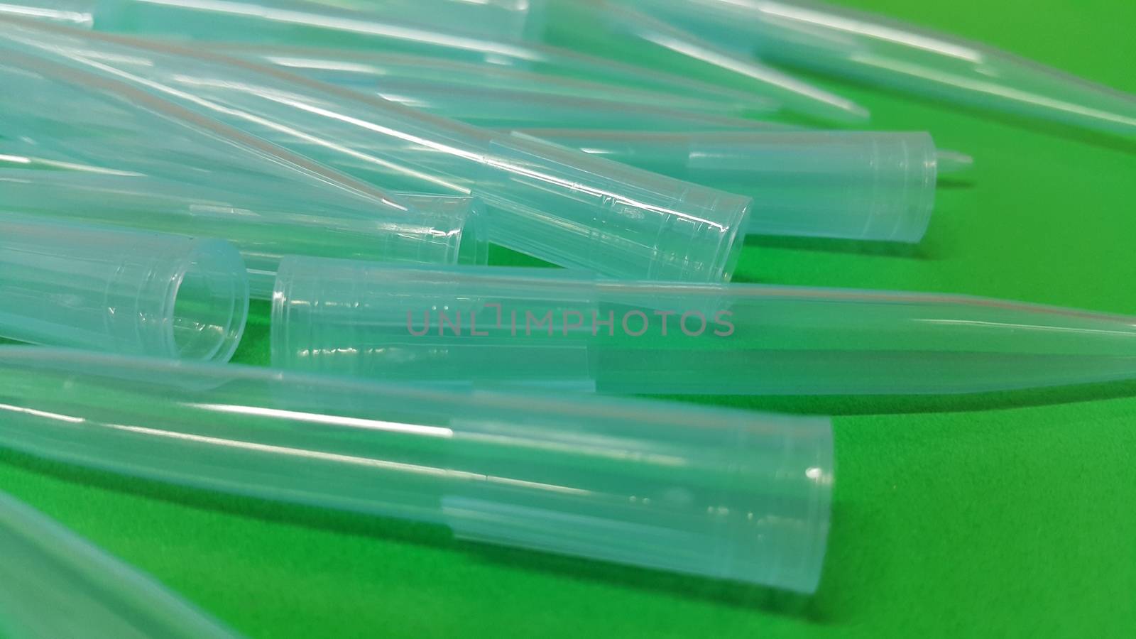 Close up view of micro litre tips on green floor sheet with empty holes. Reseach lab. tool for accurate measurement.