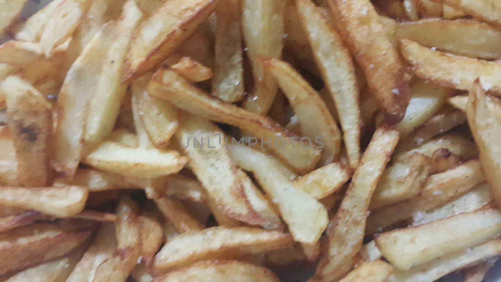 Closeup view of potato french fries or roasted potato sticks  with copy space for text