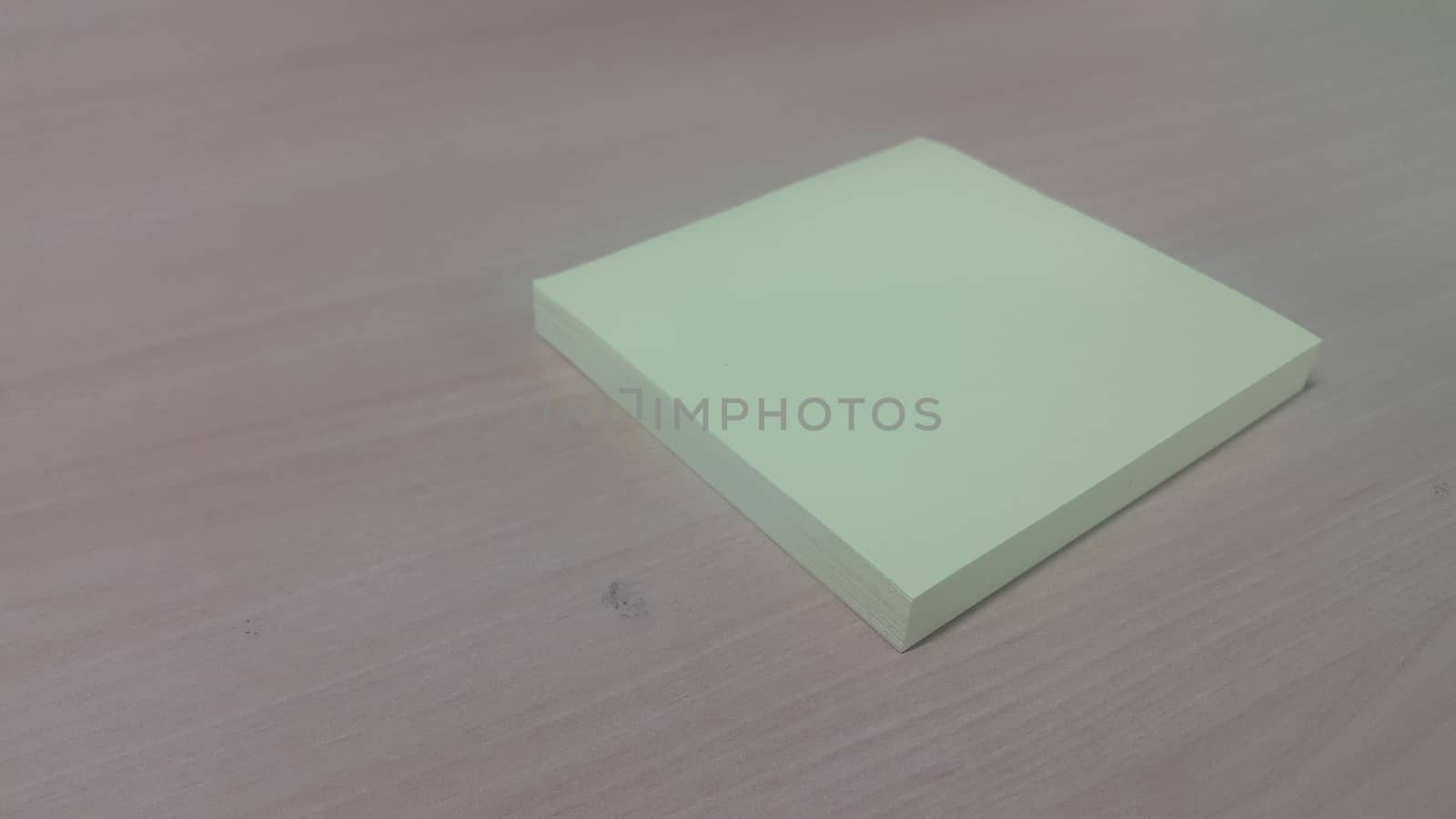 Close-up, selective focus: Yellow sticky note paper placed on a wooden table with copy space for text