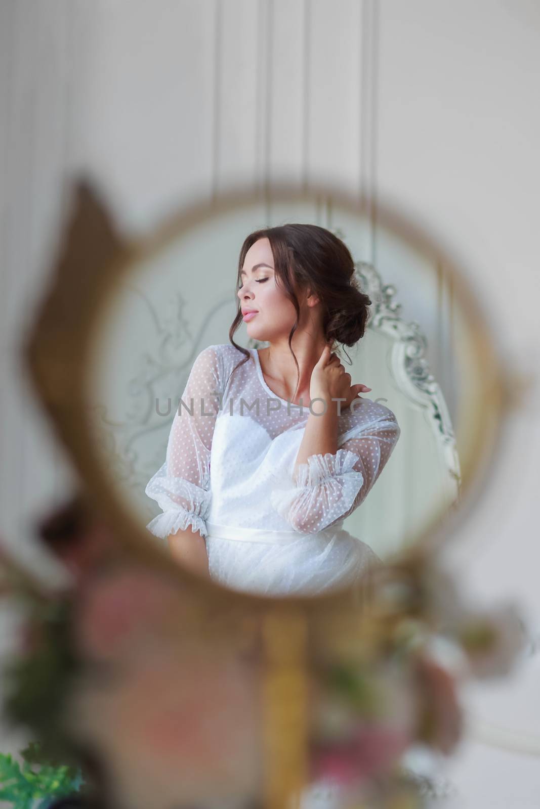Portrait of the bride in a white wedding dress in a beautiful round mirror by galinasharapova