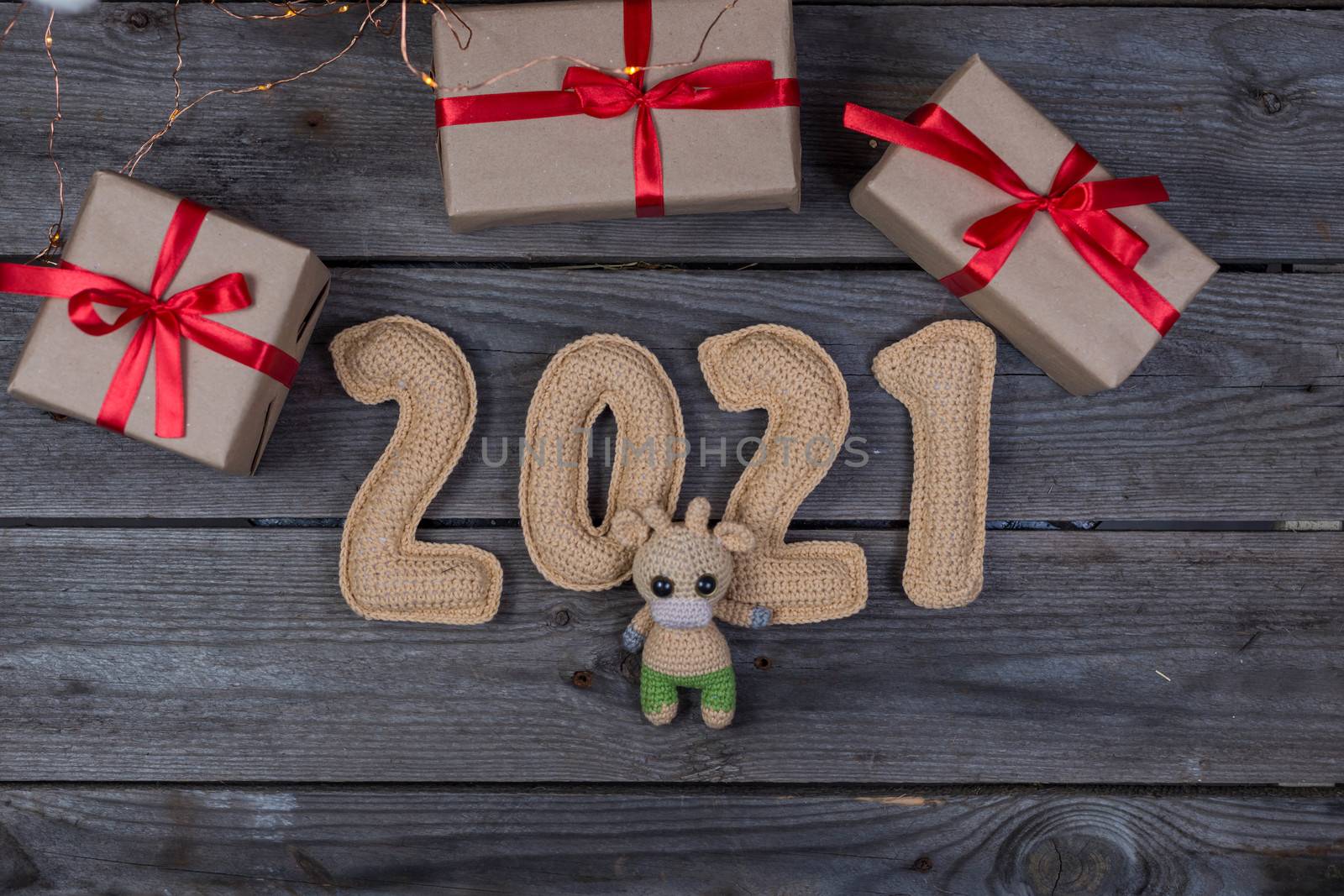 Christmas background with crocheted toy bull and numbers 2021