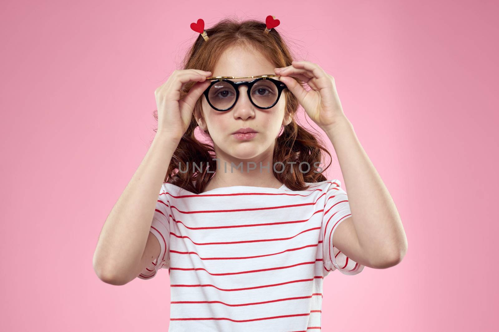 Cute girl sunglasses striped t-shirt lifestyle fun style pink background. High quality photo