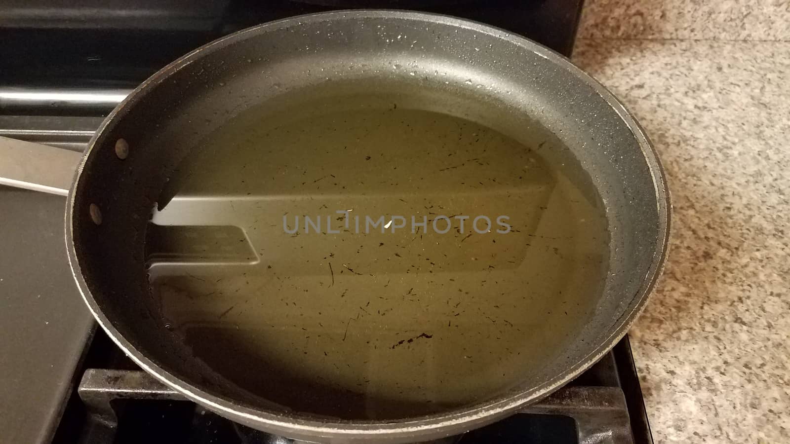 dirty frying pan on stove with used cooking oil