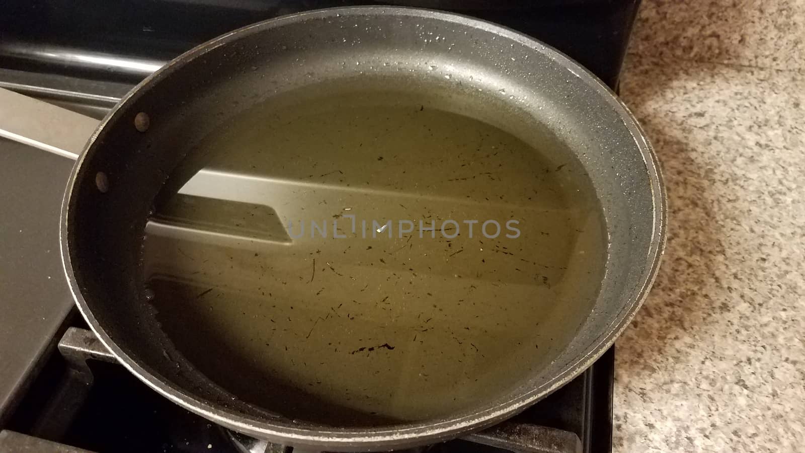 dirty frying pan on stove with used oil by stockphotofan1
