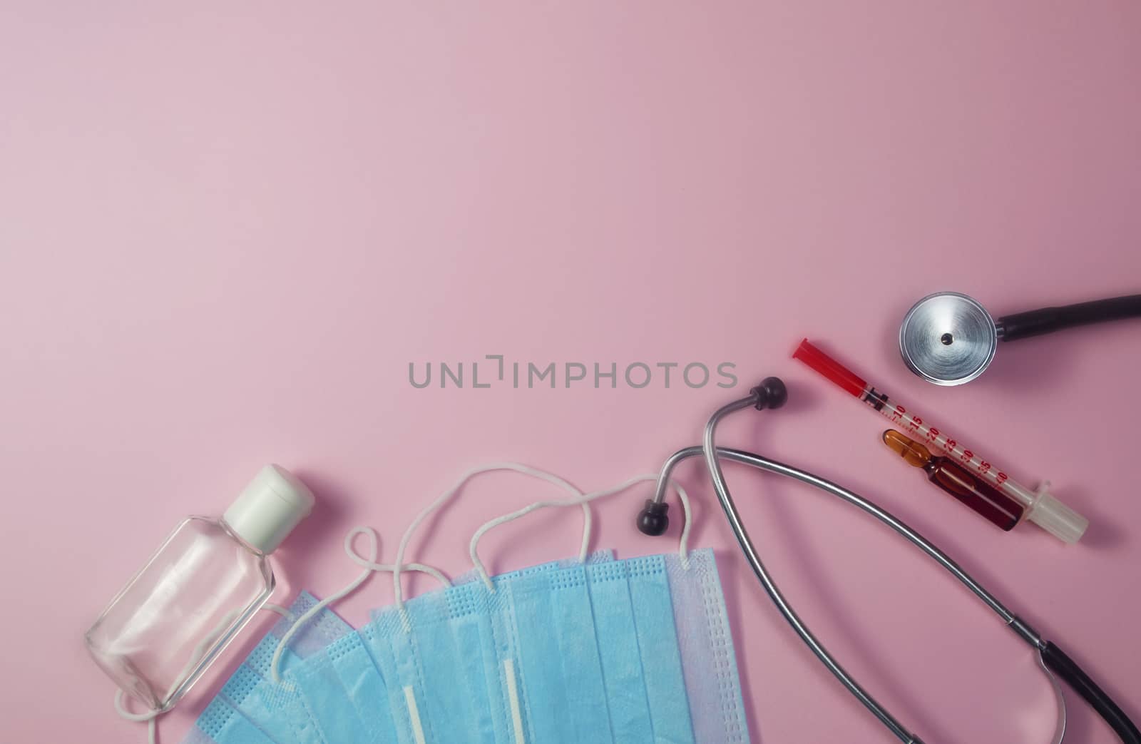 Covid-19, coronavirus treatment. Pills, stethoscope and medical masks on pink background.