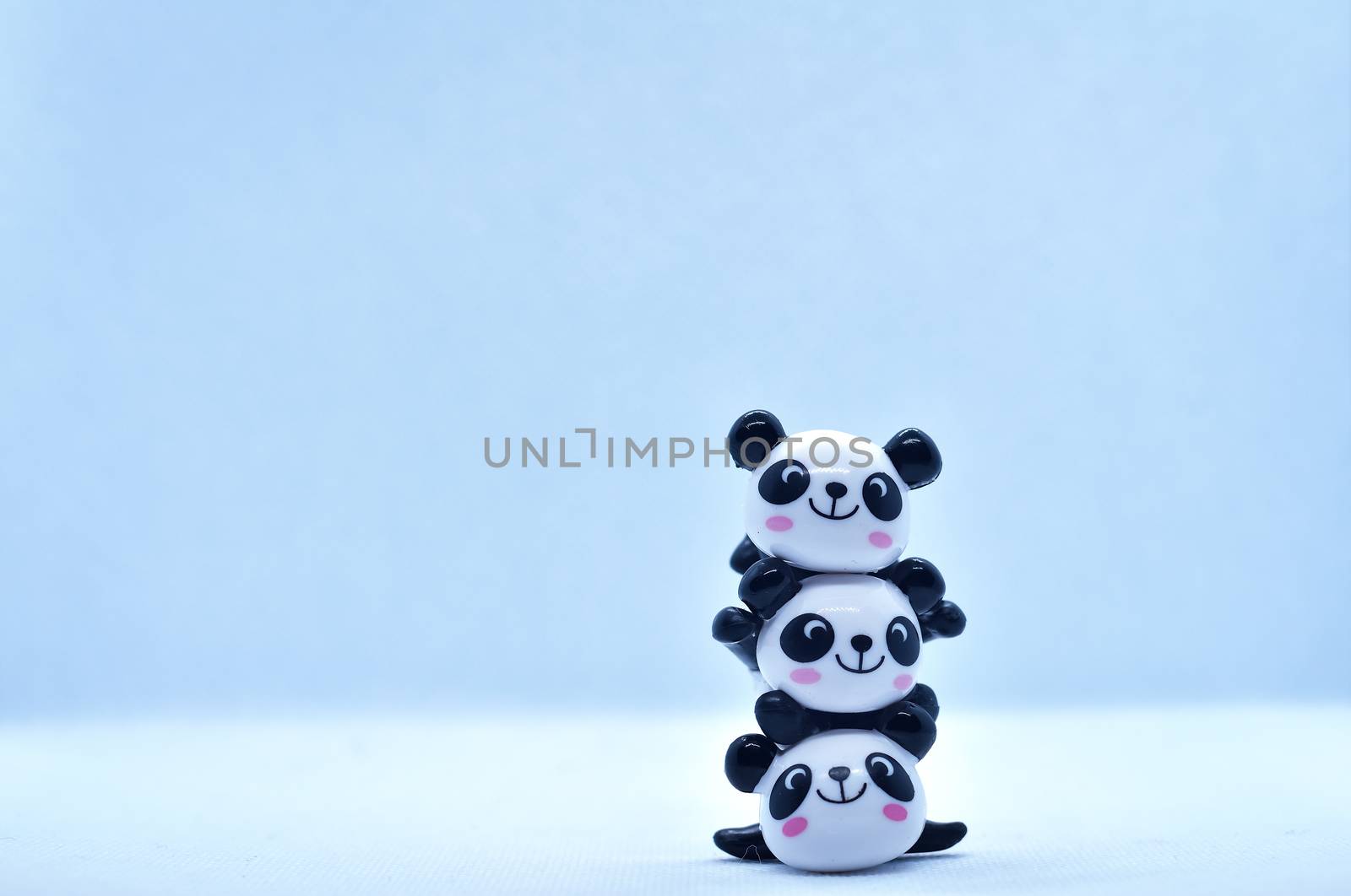 Little panda stacked porcelain figurines isolated on black background by rkbalaji