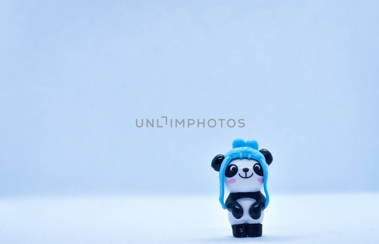 Little panda porcelain figurine isolated on black background
