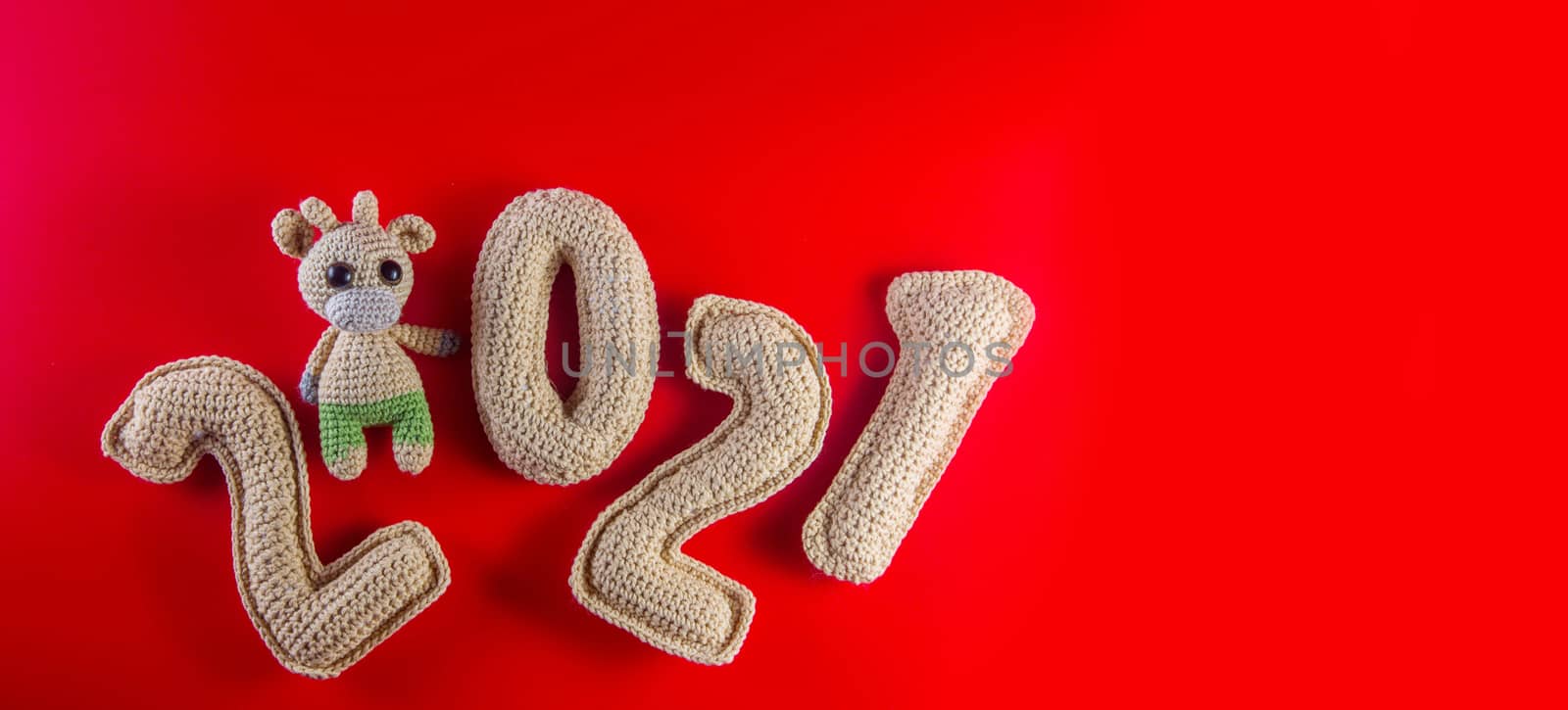 New year background with knitted toy bull symbol of chinese new year 2021