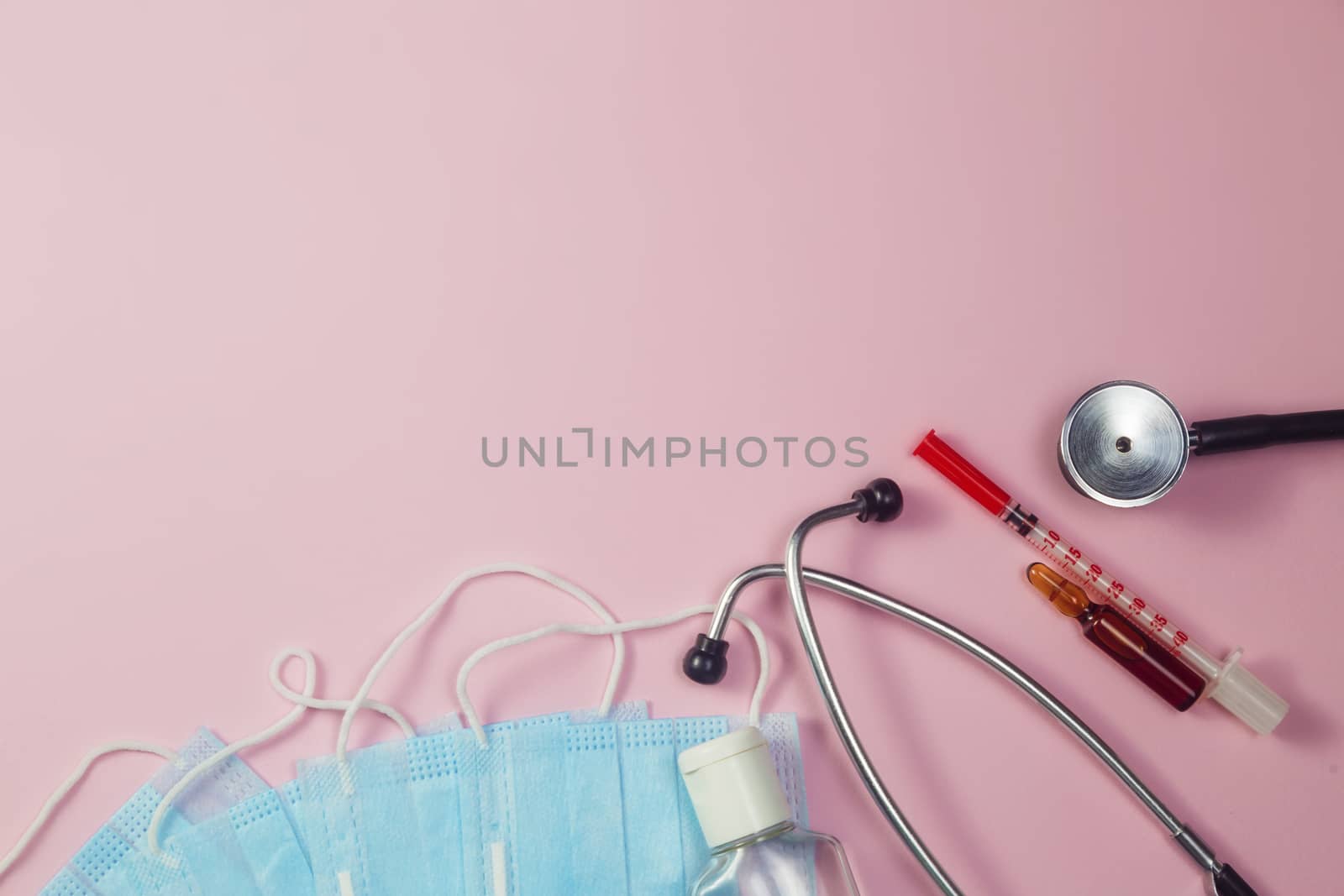 Covid-19, coronavirus treatment. Pills, stethoscope and medical masks on pink background.