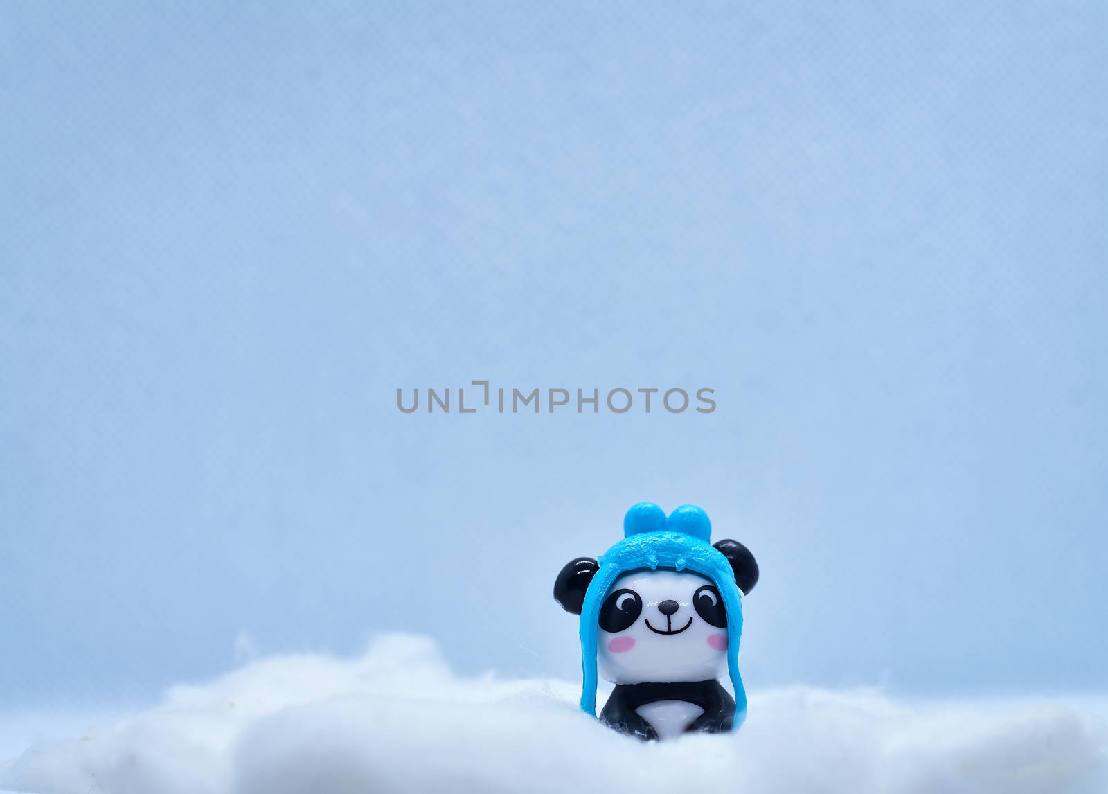 Little panda porcelain figurine in winter snow isolated on black background by rkbalaji