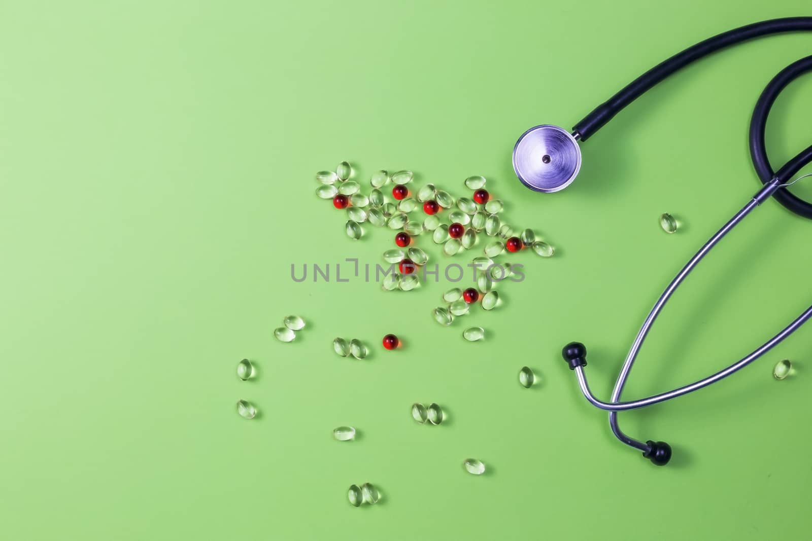 Pills, stethoscope and medical masks on green background. by galinasharapova