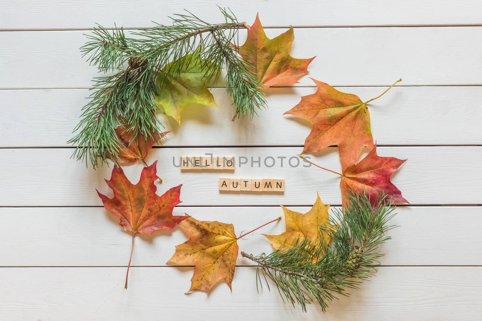 Frame made of autumn fallen leaves on wooden background.
