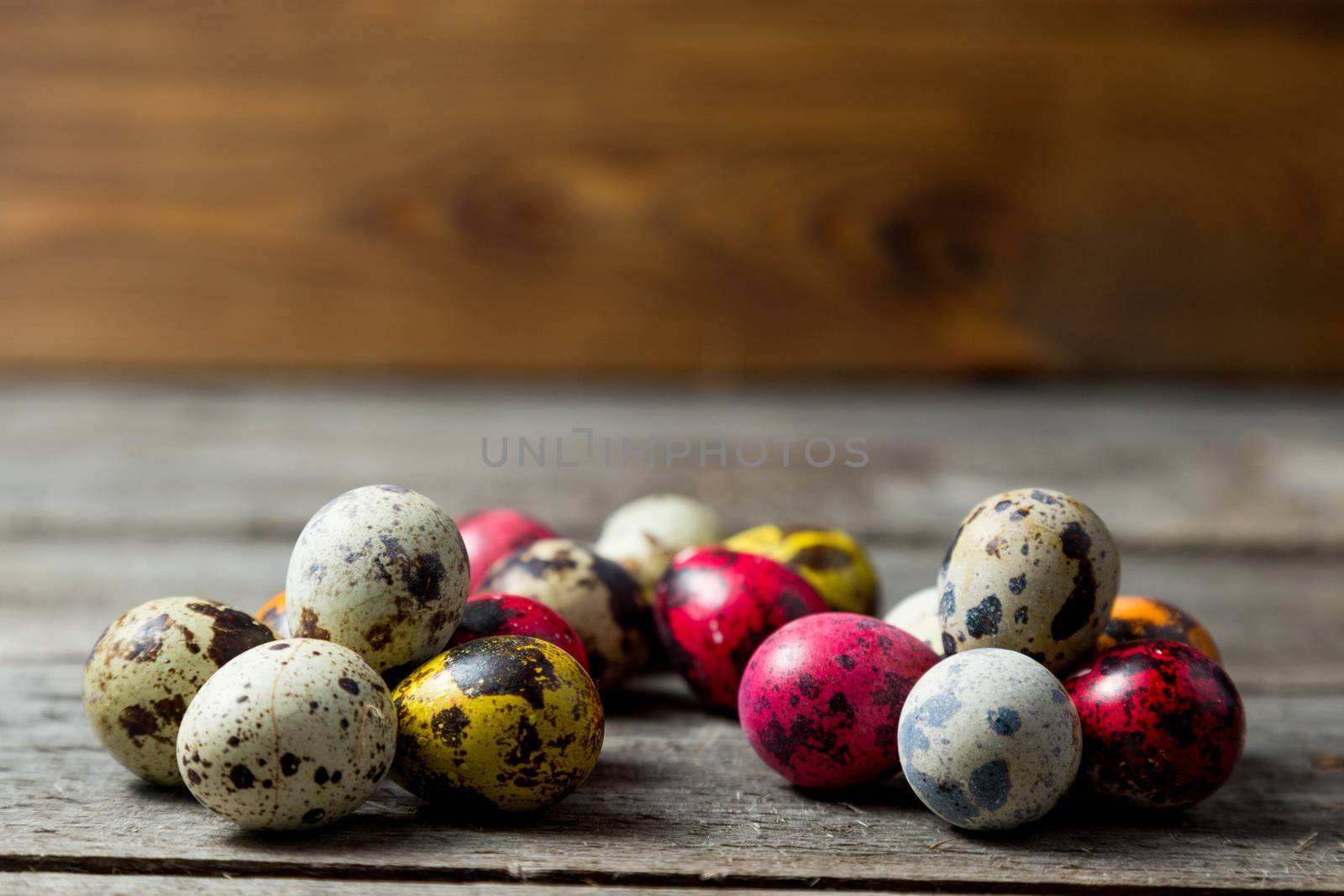.Painted easter eggs in small groups on wooden background by galinasharapova