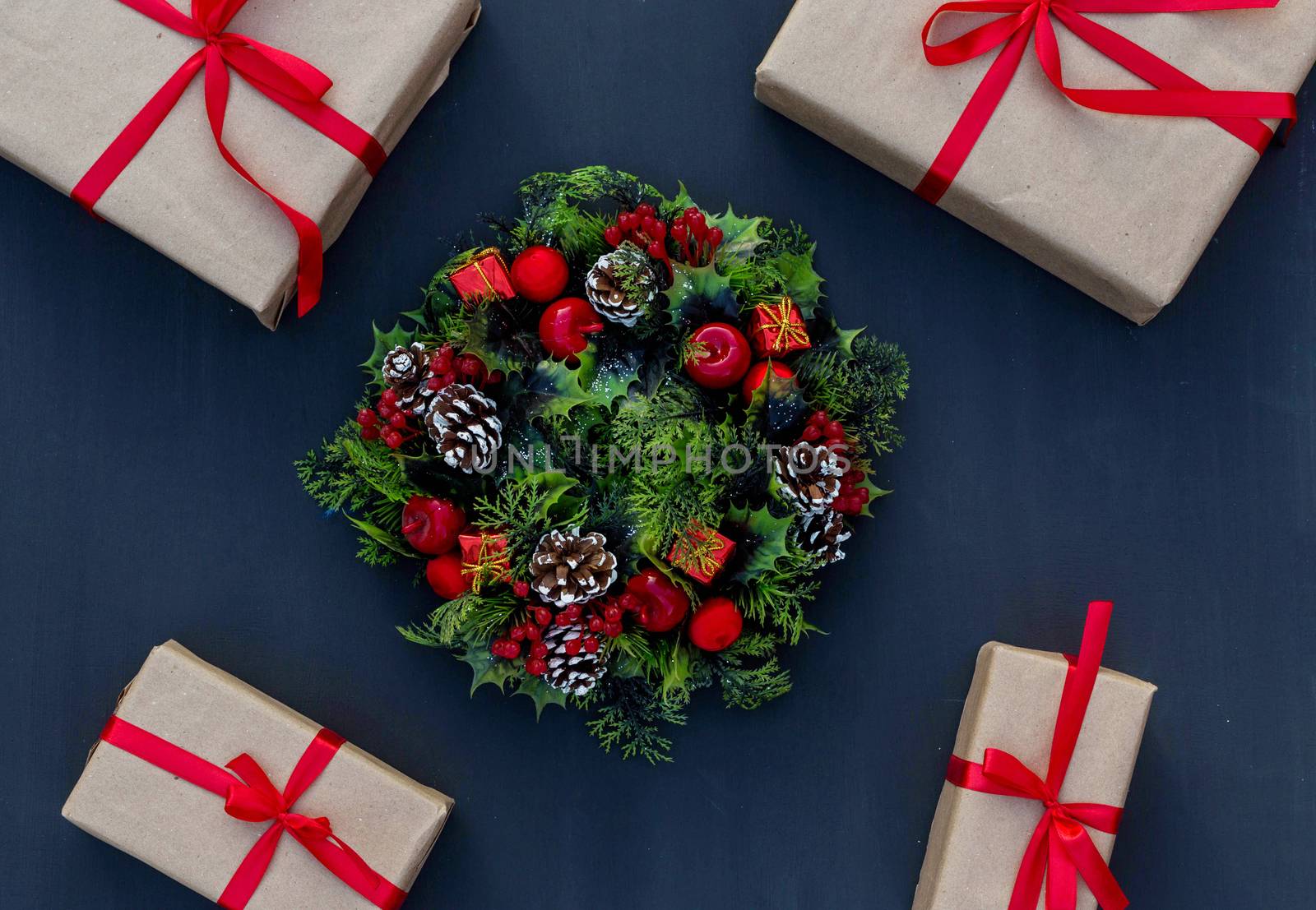 .New year wreath and gifts tied with a red ribbon on a chalk board