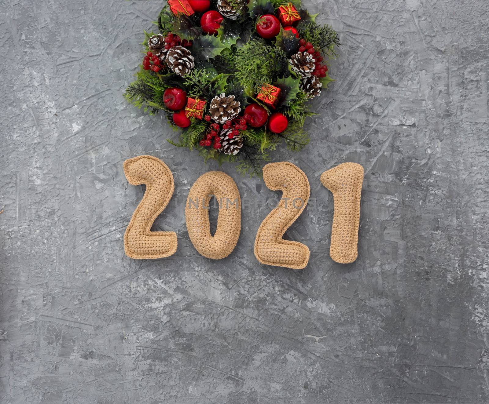 .Christmas background with knitted numbers 2021 and decorative wreath. by galinasharapova