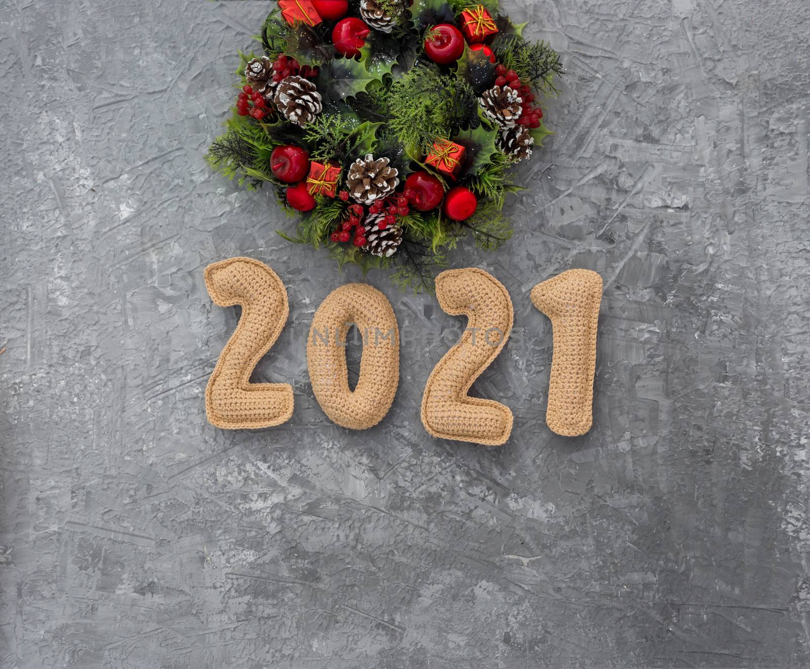 .Christmas background with knitted numbers 2021 and decorative wreath