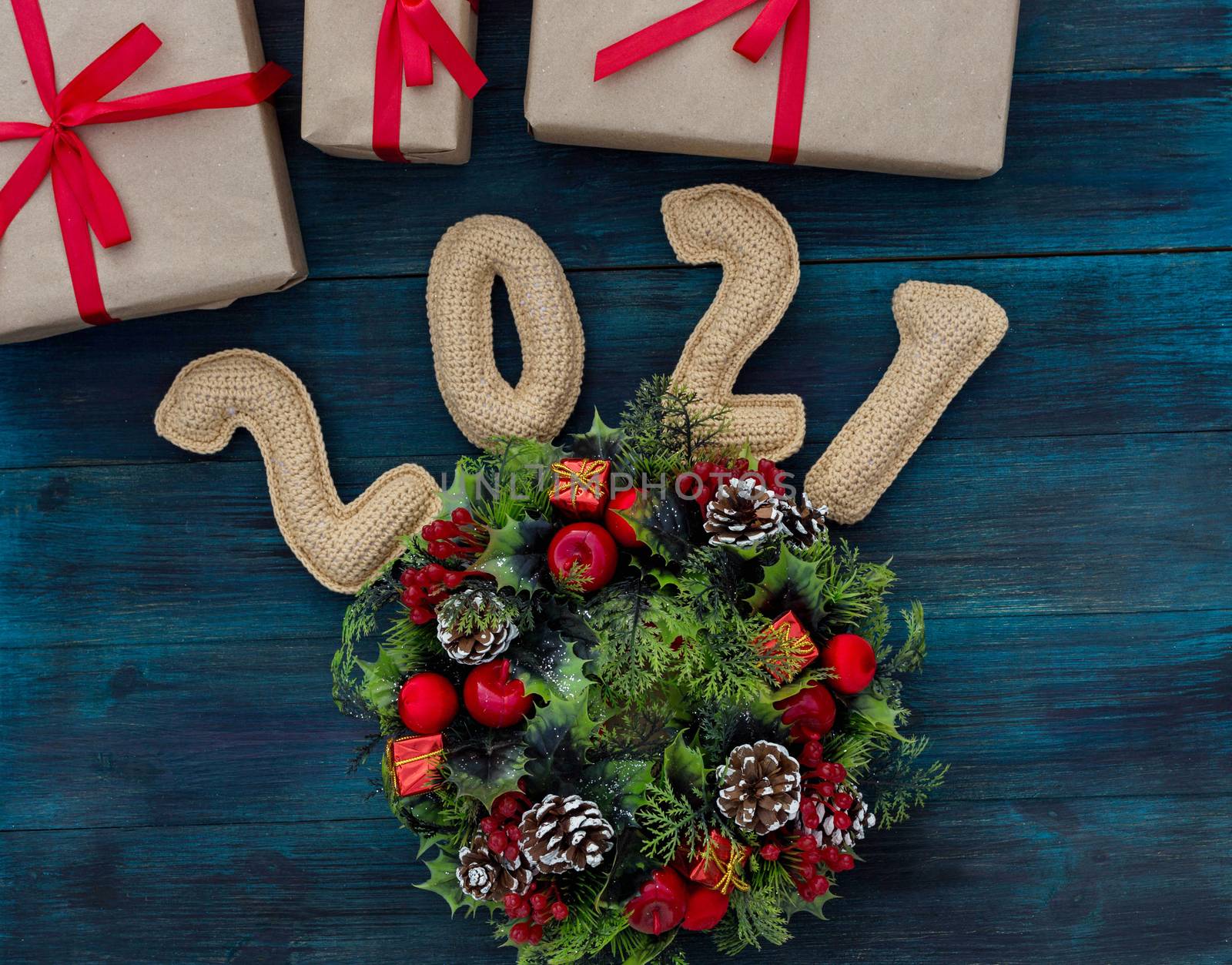 .Christmas background with knitted numbers 2021, gifts and decorative wreath by galinasharapova