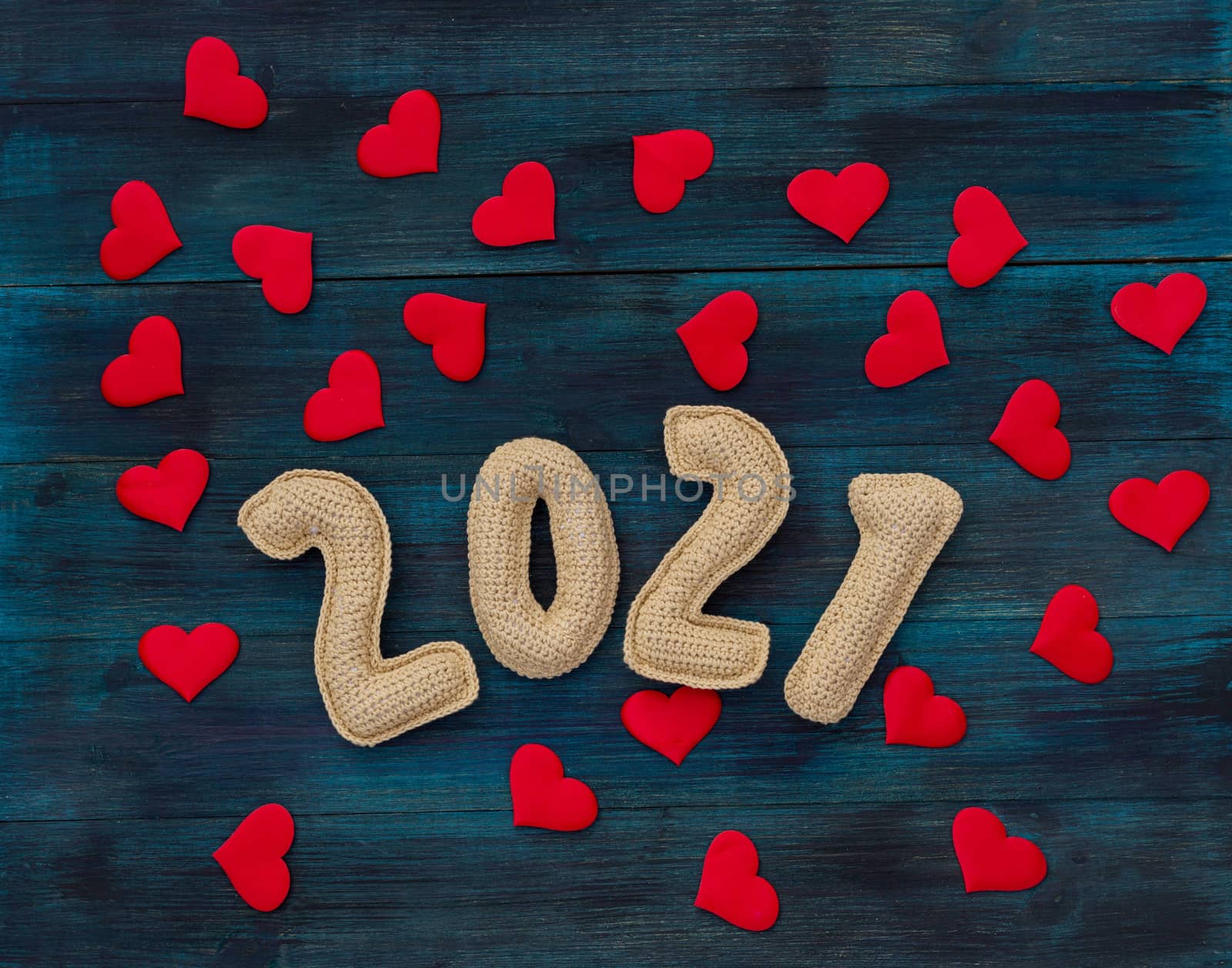 Romantic christmas background with knitted number 21 and red hearts, pandemic new year