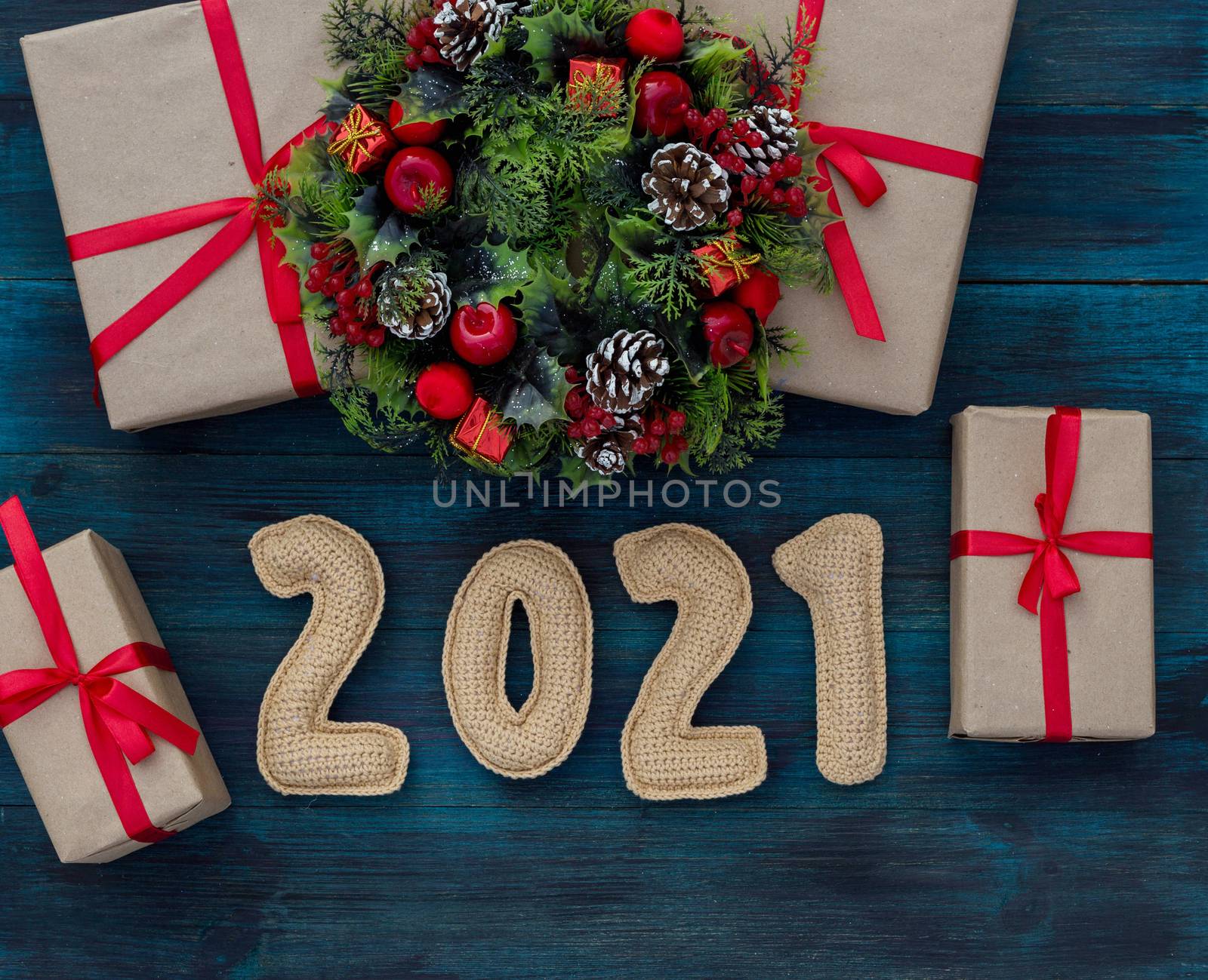 .Christmas background with knitted numbers 2021, gifts and decorative wreath by galinasharapova