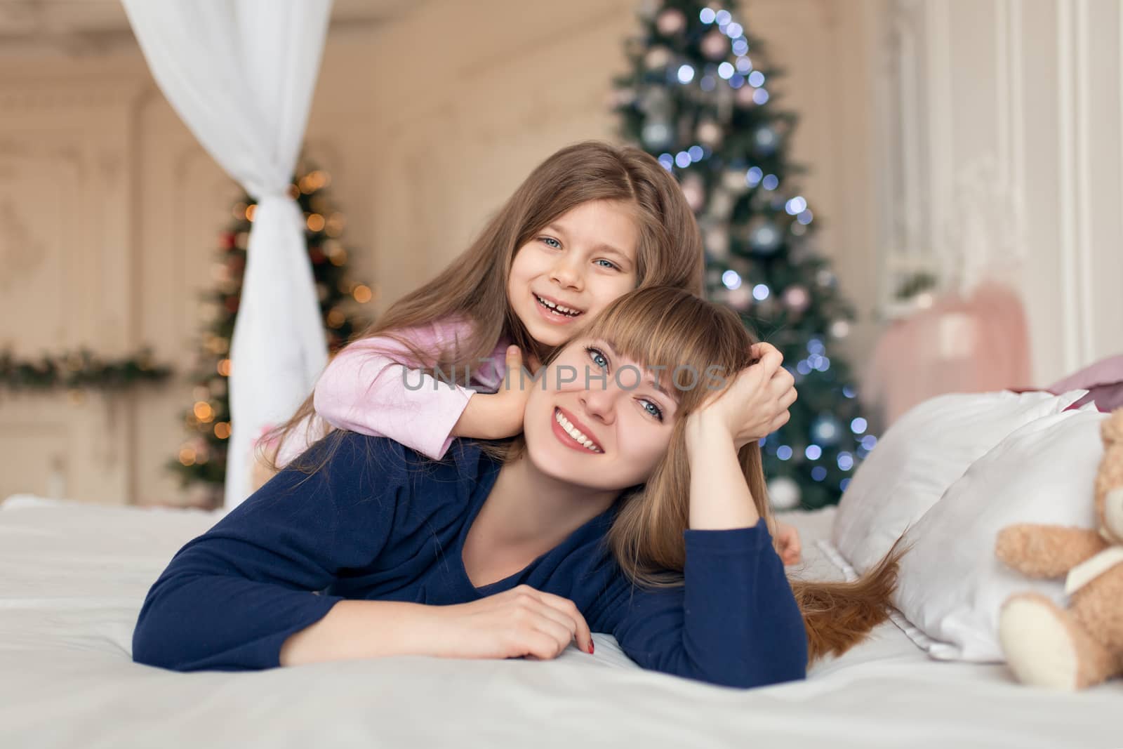Little girl spends time playing with mom while lying in bed. Christmas tale. Happy childhood by Try_my_best