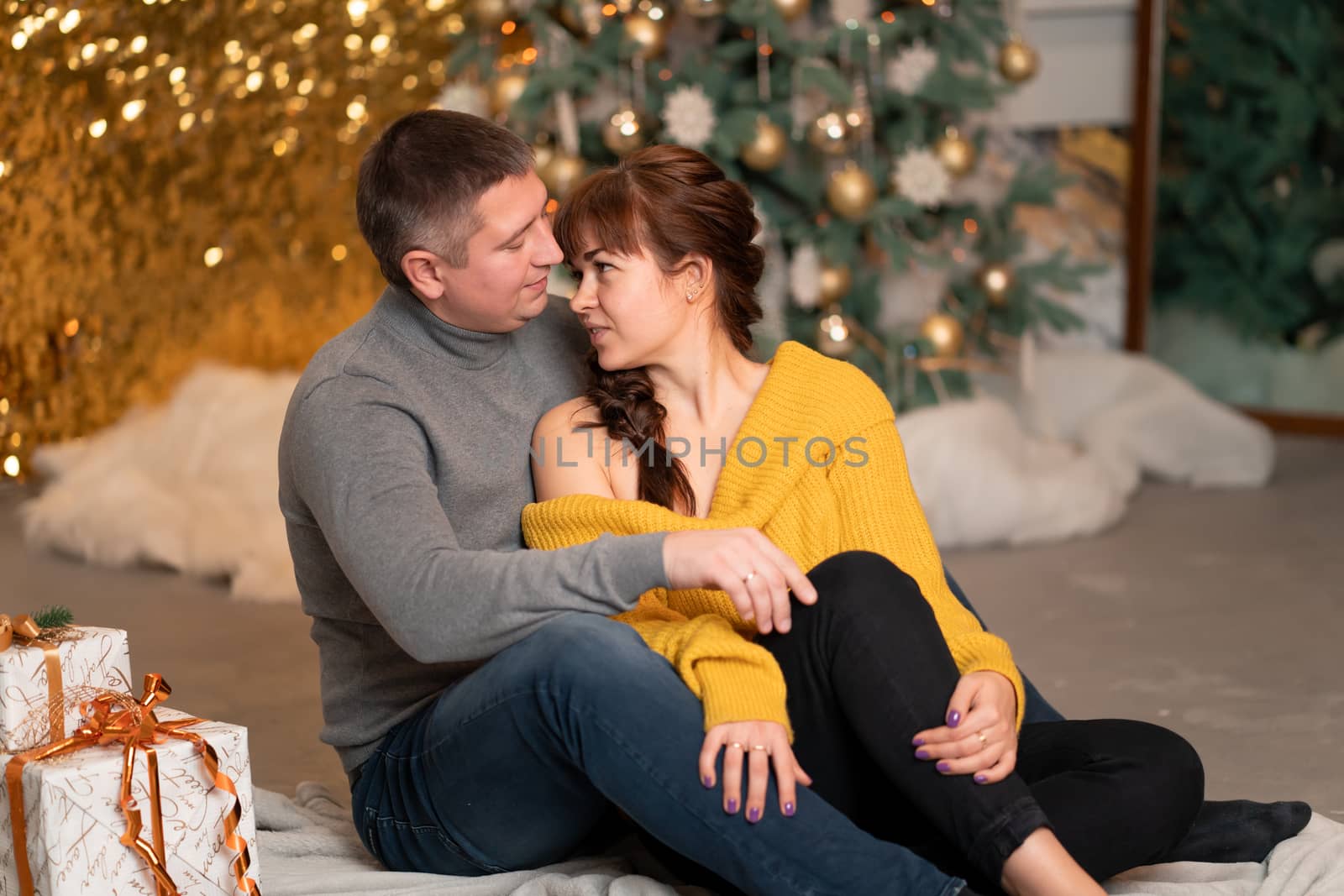 A beautiful cheerful couple greets the Christmas holidays in a cozy home atmosphere.