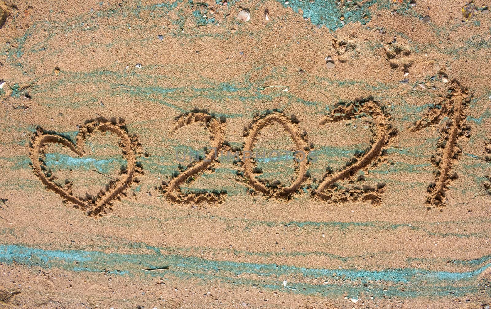 The concept of a New year. Heart and numbers 2021 in the sand. Summer beach holidays . The message is handwritten by lapushka62