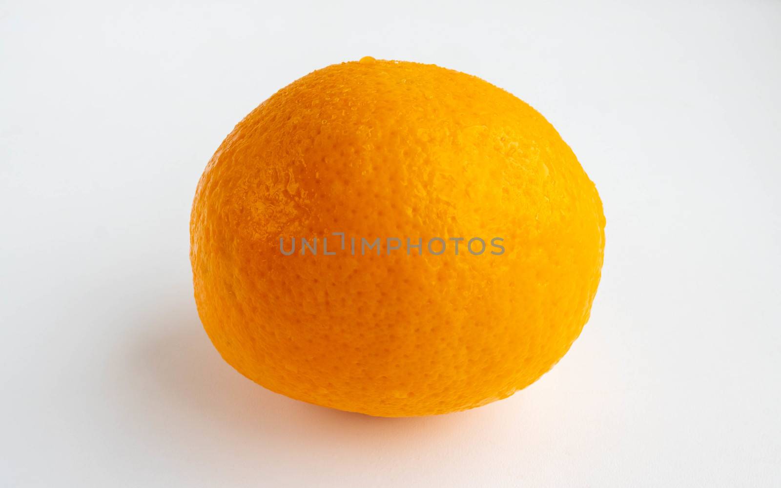 An orange lies on a white background. Harvest.