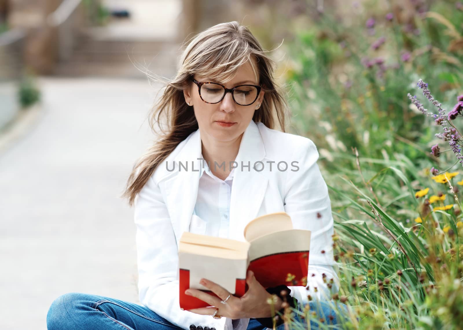 woman reading a book outside in park