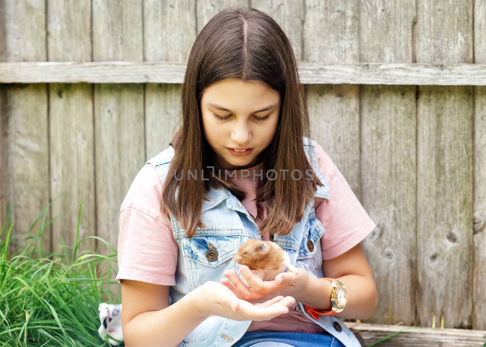 a girl holdштп a hamster in hands