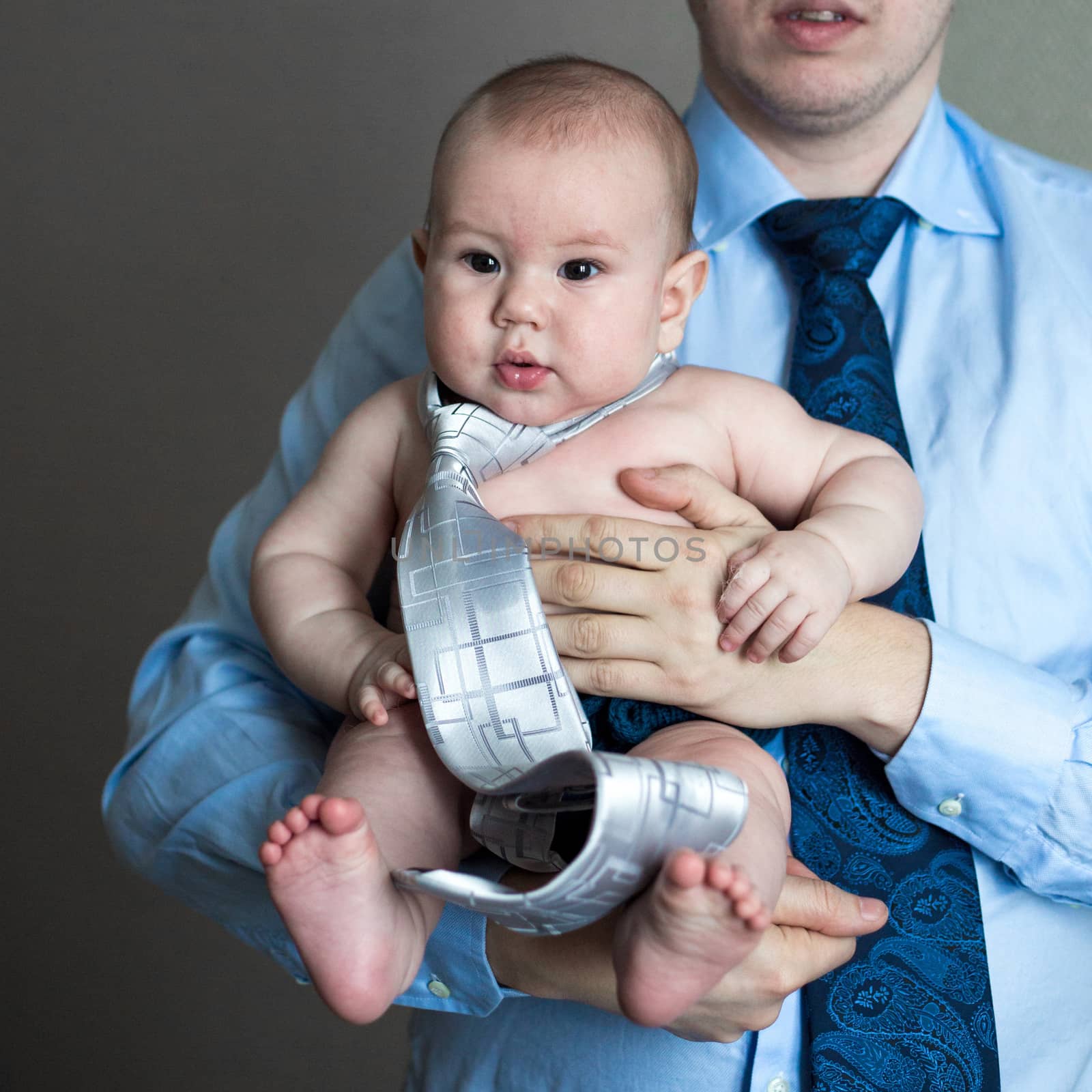 close-up portrait of a toddler boy in the arms of dad