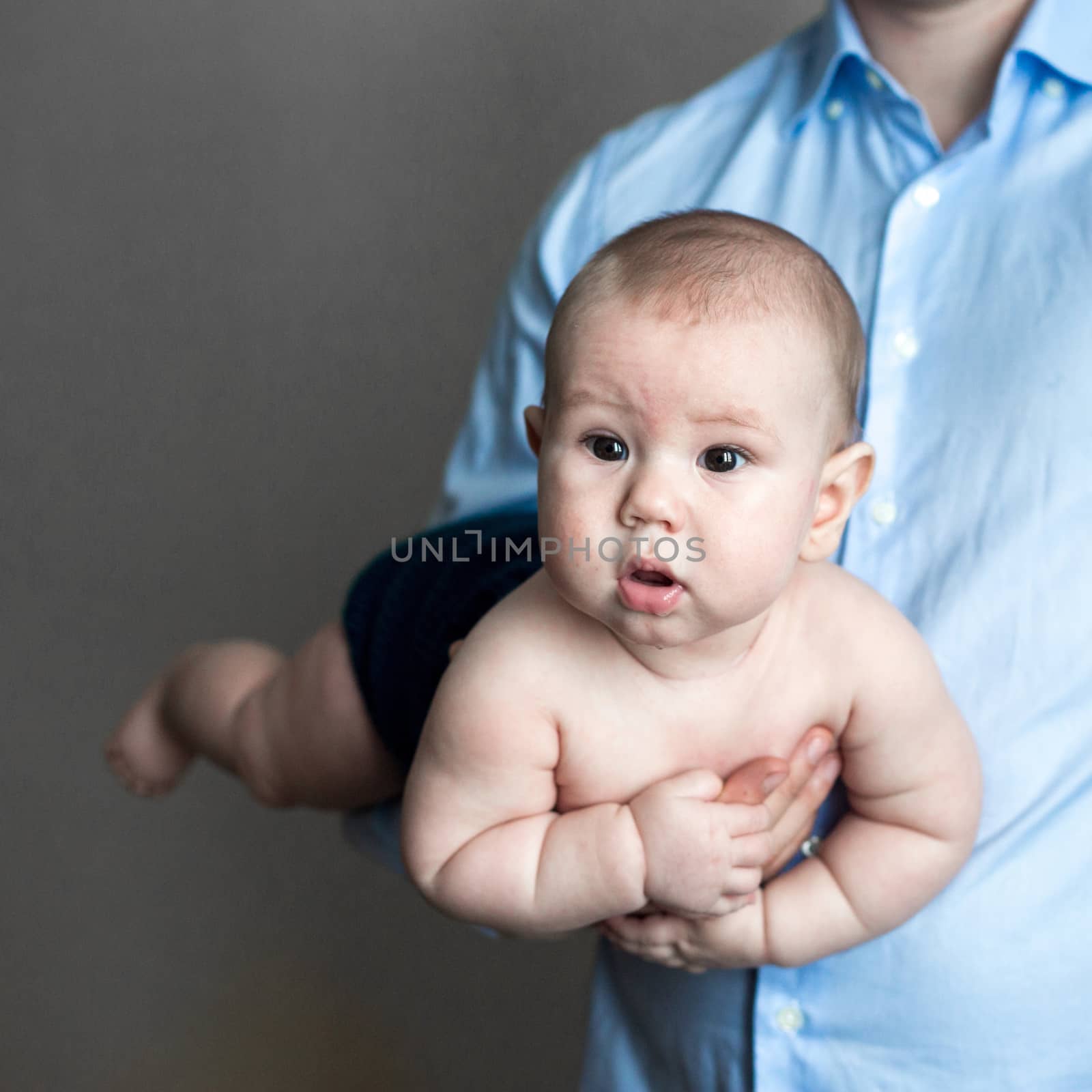 close-up portrait of a toddler boy in the arms of dad